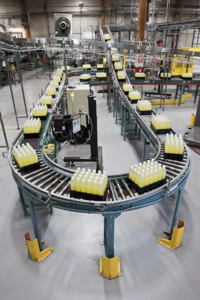 Converyor belt full of lemon flavored bottled wate D8 SAHQR