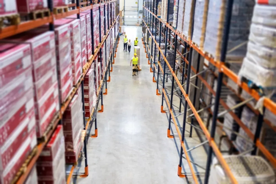 Warehouse workers at work between rows of tall she 6 TKYDMB